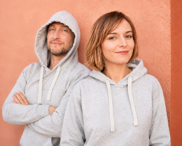 Kasia Kimel and Piotr Niewiadomski, the creators of Tipper, in grey hoodies against a terracotta wall